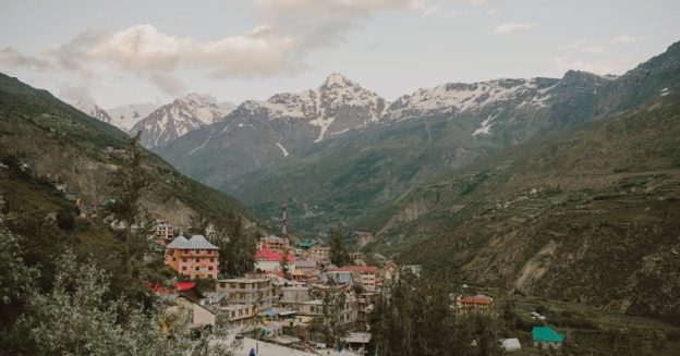 Picturesque village nestled in the Himalayan mountains of Manali, India, during a calm day.