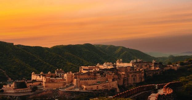 Captivating aerial shot of Amber Fort in Jaipur, Rajasthan during sunset with vibrant sky.